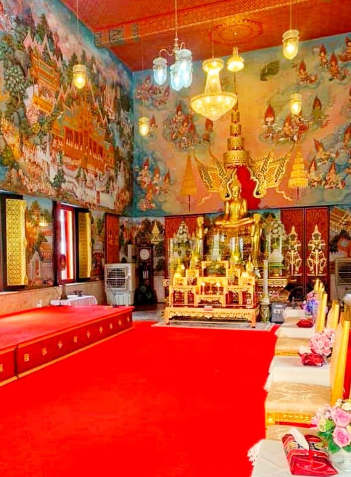 Golden Buddha statue with overhead chandelier lighting
